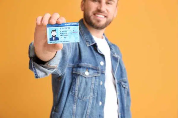 Um jovem segurando sua cnh social